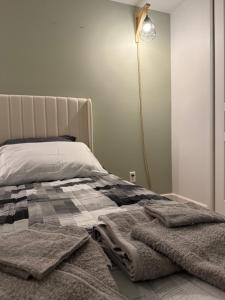 een slaapkamer met een bed met dekens en een lamp bij Cé La Vie in Québec