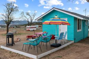 een blauw huis met een picknicktafel en een paraplu bij Starlite Vintage Resort in Buckskin Joe