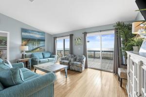 een woonkamer met blauwe meubels en uitzicht op de oceaan bij 1st Ashore-Beachfront-Pet Friendly in St. George Island