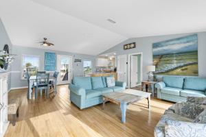 een woonkamer met blauwe banken en een tafel bij 1st Ashore-Beachfront-Pet Friendly in St. George Island