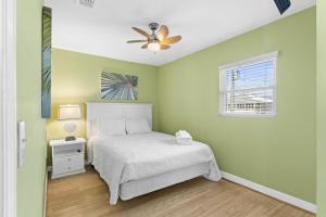 een slaapkamer met een bed en een plafondventilator bij 1st Ashore-Beachfront-Pet Friendly in St. George Island