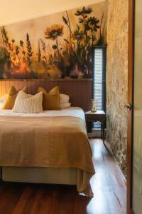 een slaapkamer met een groot bed met een schilderij aan de muur bij Rústica Estate in Quindalup