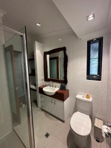 een badkamer met een toilet, een wastafel en een spiegel bij Rústica Estate in Quindalup