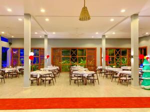 a dining room with white tables and chairs at Matemwe Sands Beach Resort in Mkuyuni Pwani