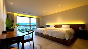 una camera da letto con un letto, una scrivania e una finestra di THE BLESS Awaji a Sumoto