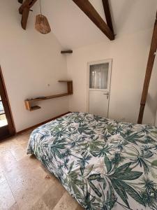 een slaapkamer met een bed met een lommerrijke sprei bij Location l'îlot tropical in Le Bois de Nèfles