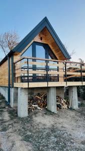 una casa con un balcone in cima a una catasta di legna di IezerVenture Cabins - Pai a Şelari