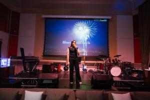 a woman standing on a stage in front of a screen at Gamers Residence in Ban Nong Chaeng +195 photos