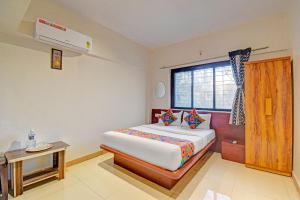 une chambre avec un grand lit et une fenêtre dans l'établissement FabHotel Nisarg Villa, à Pune