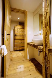 ein Badezimmer mit einem Waschbecken und Holzboden in der Unterkunft Chesa Chamuera in La Punt-Chamues-ch