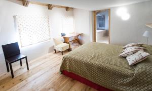 a bedroom with a bed and a desk and a chair at Chesa Chamuera in La Punt-Chamues-ch
