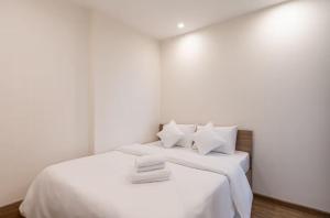 un lit blanc avec des draps blancs et des oreillers blancs dans l'établissement Homie Apartmant l Vinhomes Grand Park, à Hô-Chi-Minh-Ville