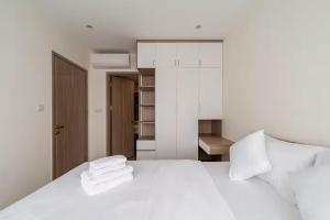 une chambre avec un lit blanc avec des serviettes dessus dans l'établissement Homie Apartmant l Vinhomes Grand Park, à Hô-Chi-Minh-Ville