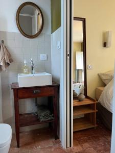 a bathroom with a sink and a mirror at Le Petit Logis in Marcigny