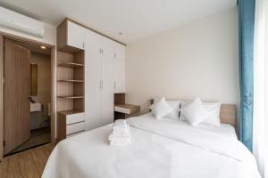 une chambre avec un grand lit blanc avec des oreillers blancs dans l'établissement Homie Apartmant l Vinhomes Grand Park, à Hô-Chi-Minh-Ville 209 autres photos