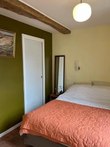 a bedroom with a bed and a mirror at Le Petit Logis in Marcigny