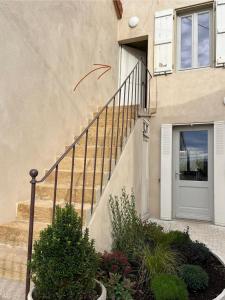 a house with a staircase with a door and a window at Le Petit Logis in Marcigny