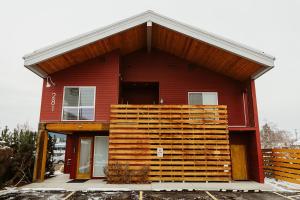 una casa rossa con una grande parete di legno di Mt Stimson Suite Near Logan Health a Kalispell
