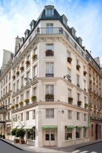 a large white building with flower boxes on it at Hôtel Cordelia Opéra-Madeleine in Paris