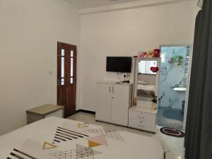 a bedroom with a bed and a cabinet and a television at Stay Roside Villa Hikkaduwa in Hikkaduwa