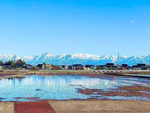 a large pool of water with mountains in the background at 高岡ゆるり家 Yururi-Ya in Takaoka