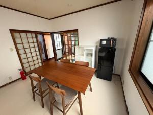 a kitchen with a wooden table and a refrigerator at 高岡ゆるり家 Yururi-Ya in Takaoka