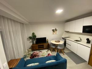 een woonkamer met een blauwe bank en een keuken bij Aveiro Studio Alboi in Aveiro