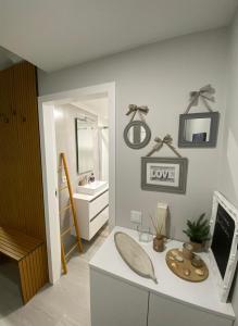 een badkamer met een wastafel en een bureau met een spiegel bij Aveiro Studio Alboi in Aveiro