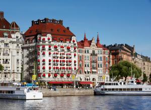 dwie łodzie w wodzie przed budynkami w obiekcie Hotel Diplomat Stockholm w Sztokholmie