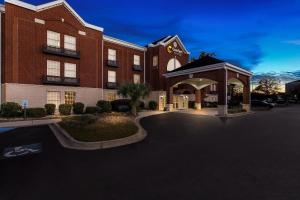 a large red brick building with a parking lot at Comfort Suites Sumter near Shaw AFB in Sumter