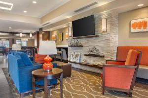 a living room with furniture and a flat screen tv at Comfort Suites Florence - Cincinnati South in Florence