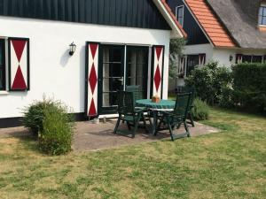 a table and chairs in front of a house at Villa Julia 148 in Callantsoog