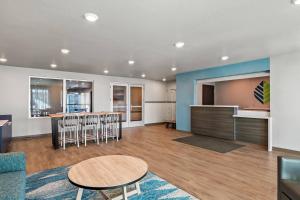 a living room with a table and chairs and a kitchen at WoodSpring Suites Palm Springs - West Palm Beach in Palm Springs