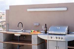 a kitchen with a sink and a counter with a grill at Villa Trilux, Infinity Pool, Jacuzzi, BBQ in Salobre