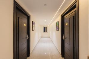 ein Flur mit zwei schwarzen Türen und einem langen Korridor in der Unterkunft Treebo Ss Residency Gandhi Nagar in Vijayawāda