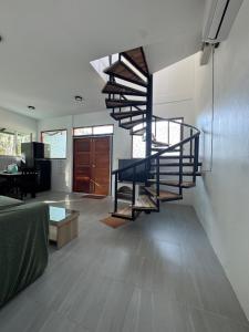 a living room with a spiral staircase in a house at Woodland Residence in Wok Tum