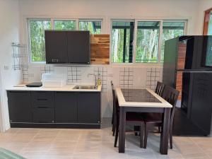 a kitchen with a sink and a table with chairs at Woodland Residence in Wok Tum