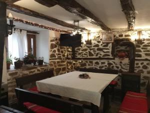 une salle à manger avec une table et un mur en pierre dans l'établissement Vitanova Guest House, à Genchovtsi