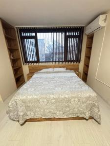 una camera da letto con un letto e una grande finestra di Mini House Shumen a Shumen