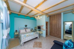 a bedroom with a crib in a room with blue walls at Sobe Gora in Posedarje