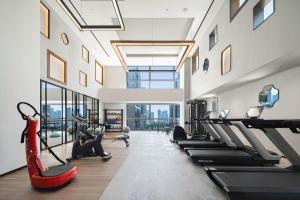 une salle de sport avec tapis de course et machines elliptiques dans l'établissement Mumian Rizhao Hotel, à Rizhao