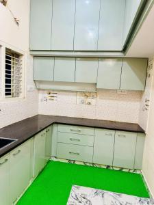 eine Küche mit weißen Schränken und einem grünen Boden in der Unterkunft Flats in city center, next to NEXUS MALL in Mysore