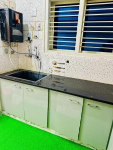 eine Küche mit Spüle und grünem Boden in der Unterkunft Flats in city center, next to NEXUS MALL in Mysore + 22 Fotos