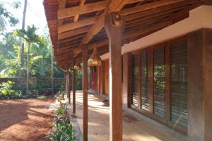 a porch of a house with a wooden roof at Salt Water Sanctuary in Diveagar