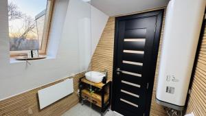 een badkamer met een zwarte deur en een wastafel bij IezerVenture Cabins - Chiang Rai in FierbinÅ£i +15 foto's