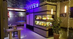 un restaurant avec des lumières violettes et un comptoir avec de la nourriture dans l'établissement RungRoj Panich Hotel, à Ban Bang Saen