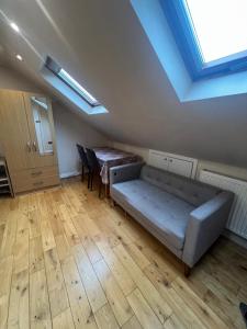 a living room with a couch and a table at Spacious and Modern En-suit in Harrow on the Hill