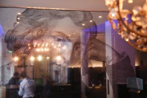 a person standing in front of a large mirror at Schiller 5 Hotel in Munich