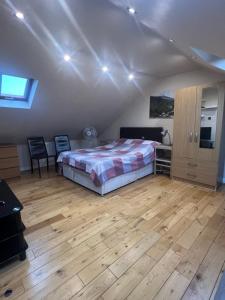 a bedroom with a bed and a wooden floor at Spacious and Modern En-suit in Harrow on the Hill