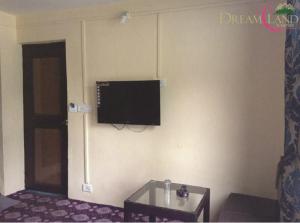 a living room with a tv on a wall at Dreamland Cottage in Pahalgām